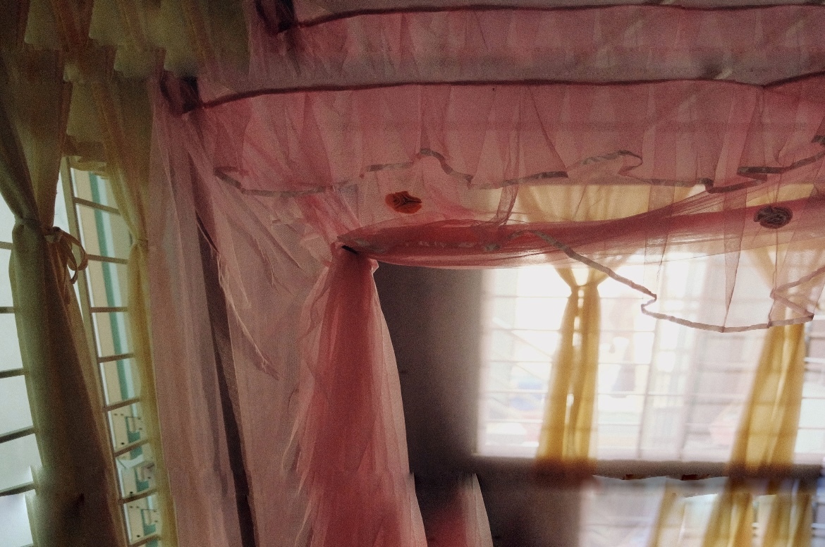 Soft daylight passing through pink fabric in an interior.